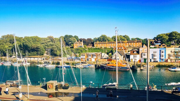 A harbor with boats, buildings, and a clear sky. - The Ocean Guesthouse (Weymouth)