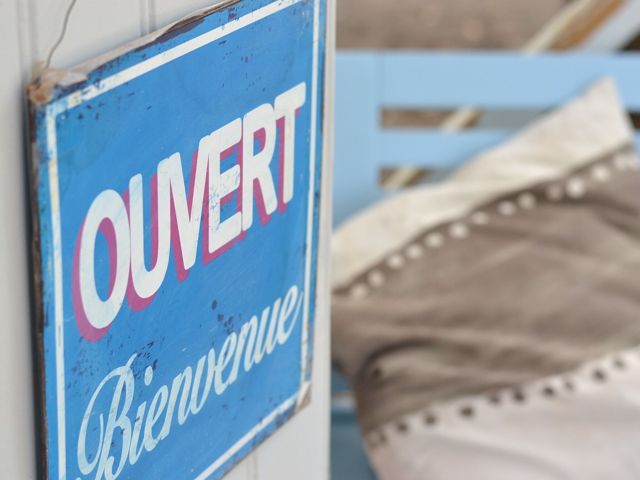 Une enseigne sur laquelle on peut lire les mots « OUVERT » et « Bienvenue ».