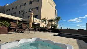 A hot tub in a courtyard with a building in the background. - Class Hotel Rio Claro (Rio Claro)