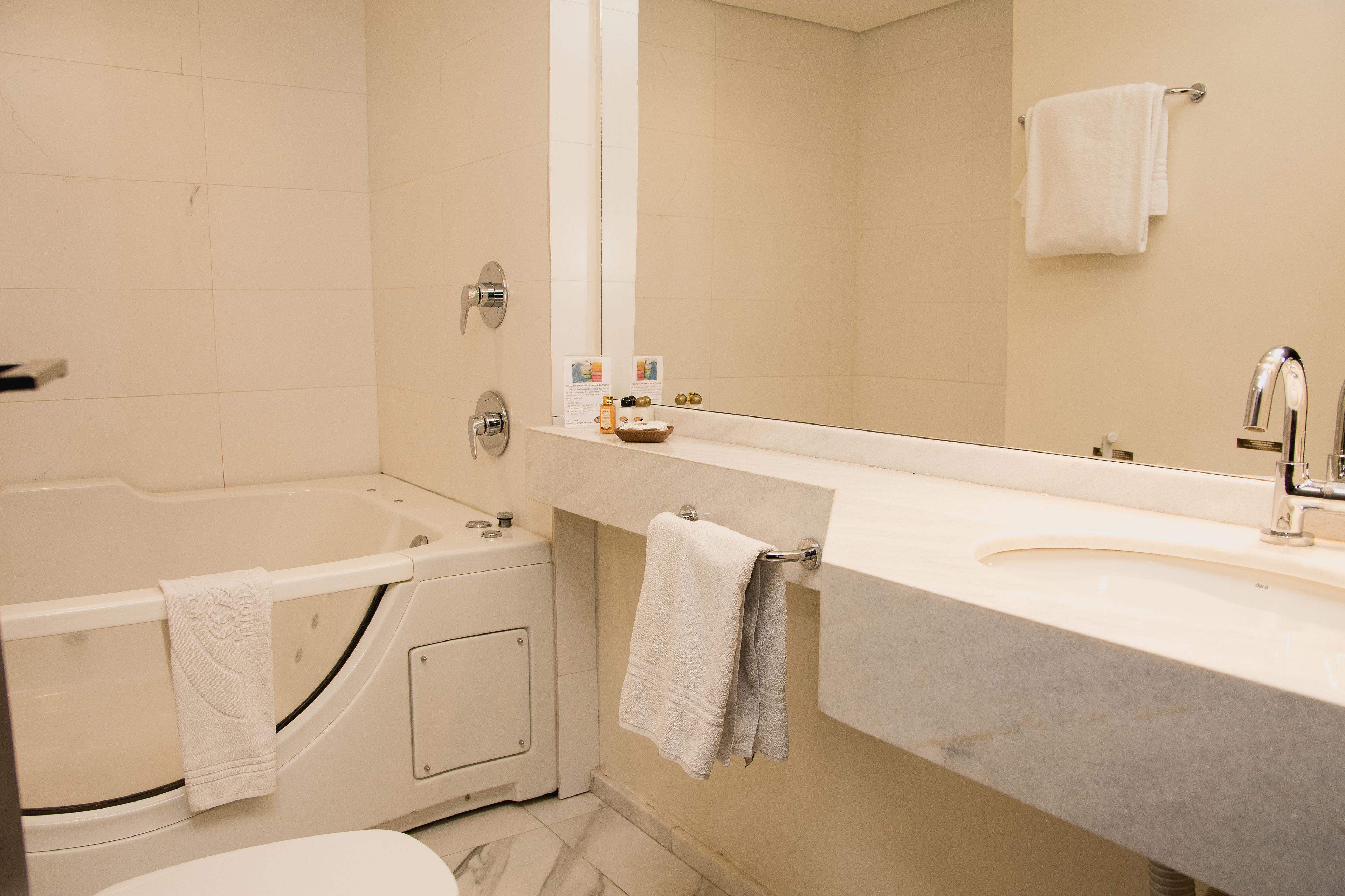 A modern bathroom with a bathtub, a sink, and a large mirror.