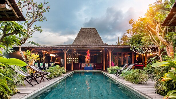 A pool area with lounge chairs and a covered seating area. - Villa Gambar (Kerobokan)
