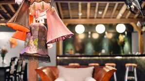 A bar area with a cushioned seating arrangement, a counter, and hanging decorative lamps. - Villa Gambar (Kerobokan)