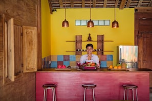 A kitchen with a wooden island, hanging copper pendant lights, and a colorful backsplash. - Villa Madah (Kerobokan)