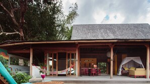A wooden villa with a pool, outdoor seating, and a covered dining area. - Villa Madah (Kerobokan)