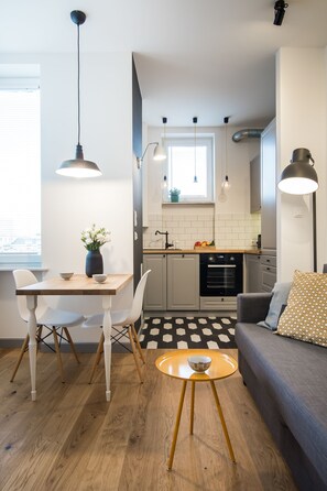 Een moderne keuken met witte kastjes, een zwarte oven en een raam boven de spoelbak.