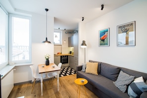 A modern apartment with a dining area, kitchen, and living room.