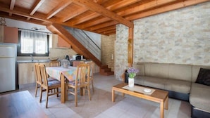A cozy interior with a dining area, a sofa, and a kitchen. - Stergios Villa (Rhodes)