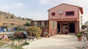 A two-story building with a red roof, a satellite dish, and a small window. - Stergios Villa (Rhodes)