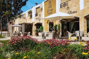 Un hotel con terraza y jardín.
