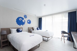 Una habitación de hotel con dos camas, un escritorio y una silla.