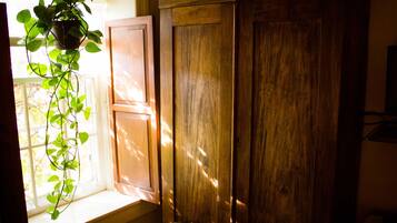 A wooden cabinet with a window sill and a hanging plant.