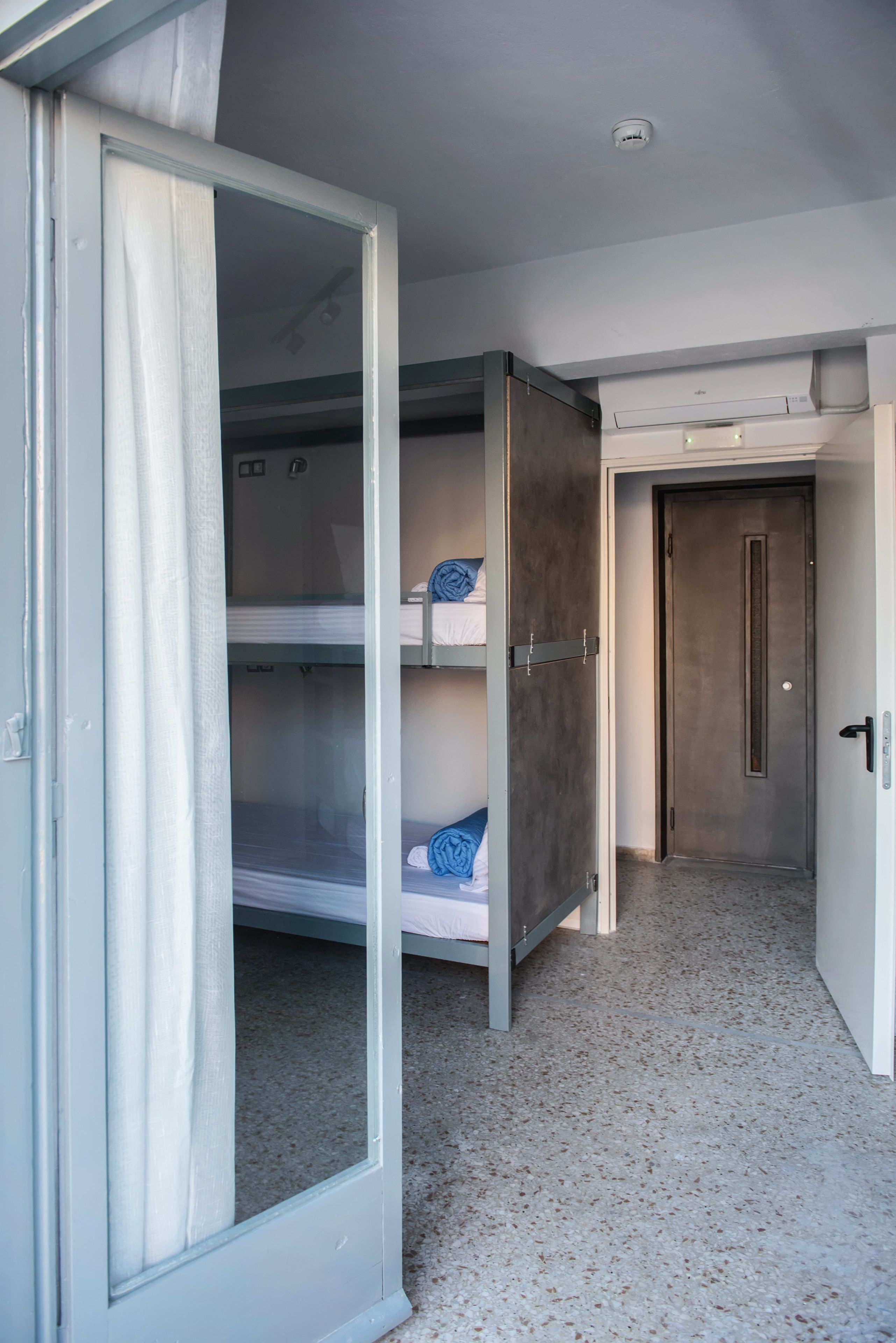 A room with bunk beds, a door, and a ceiling light.