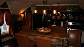 A cozy dining area with a wooden table, wicker basket, and leather chairs.