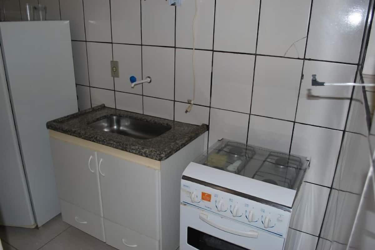 Eine Küche mit Granit-Arbeitsplatte, Spüle, weißen Schränken und einem eingebauten Backofen.