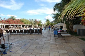 Un espace aménagé au bord de la piscine, avec des chaises longues, des parasols et un coin salon abrité.