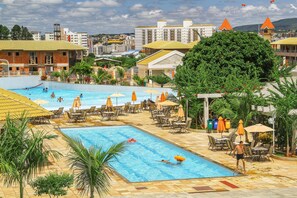 A swimming pool with multiple lanes, lounge chairs, and umbrellas.