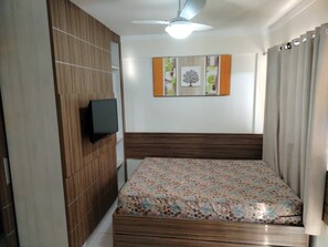 A bedroom with a bed, a television mounted on the wall, and a ceiling fan. - Apartment Lacqua DiRoma IV - JC Temporada (Caldas Novas)