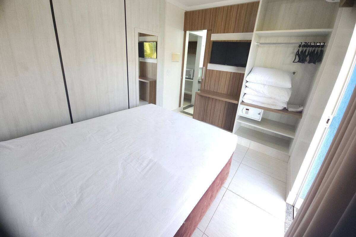 Een slaapkamer met een bed, een kledingkast en een inloopkast.