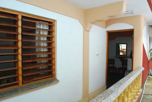 A corridor with a wooden window and a yellow balustrade.