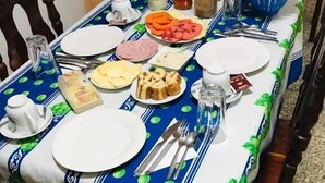 Una mesa de comedor dispuesta con platos, cubiertos y diferentes alimentos.