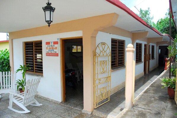 A building with a sign indicating it is a house named 'Casa El Garaje' and a gate.