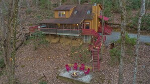A cabin with a deck, a fire pit, and outdoor seating. - Hot Tub - Screen Porch - Rockers - Fire Pit - Cozy - Clean - Fast Wi-Fi - 5 Star (Maggie Valley)