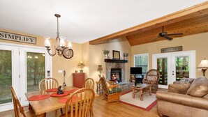 A cozy living room with a fireplace, wooden furniture, and a chandelier. - Hot Tub - Screen Porch - Rockers - Fire Pit - Cozy - Clean - Fast Wi-Fi - 5 Star (Maggie Valley)