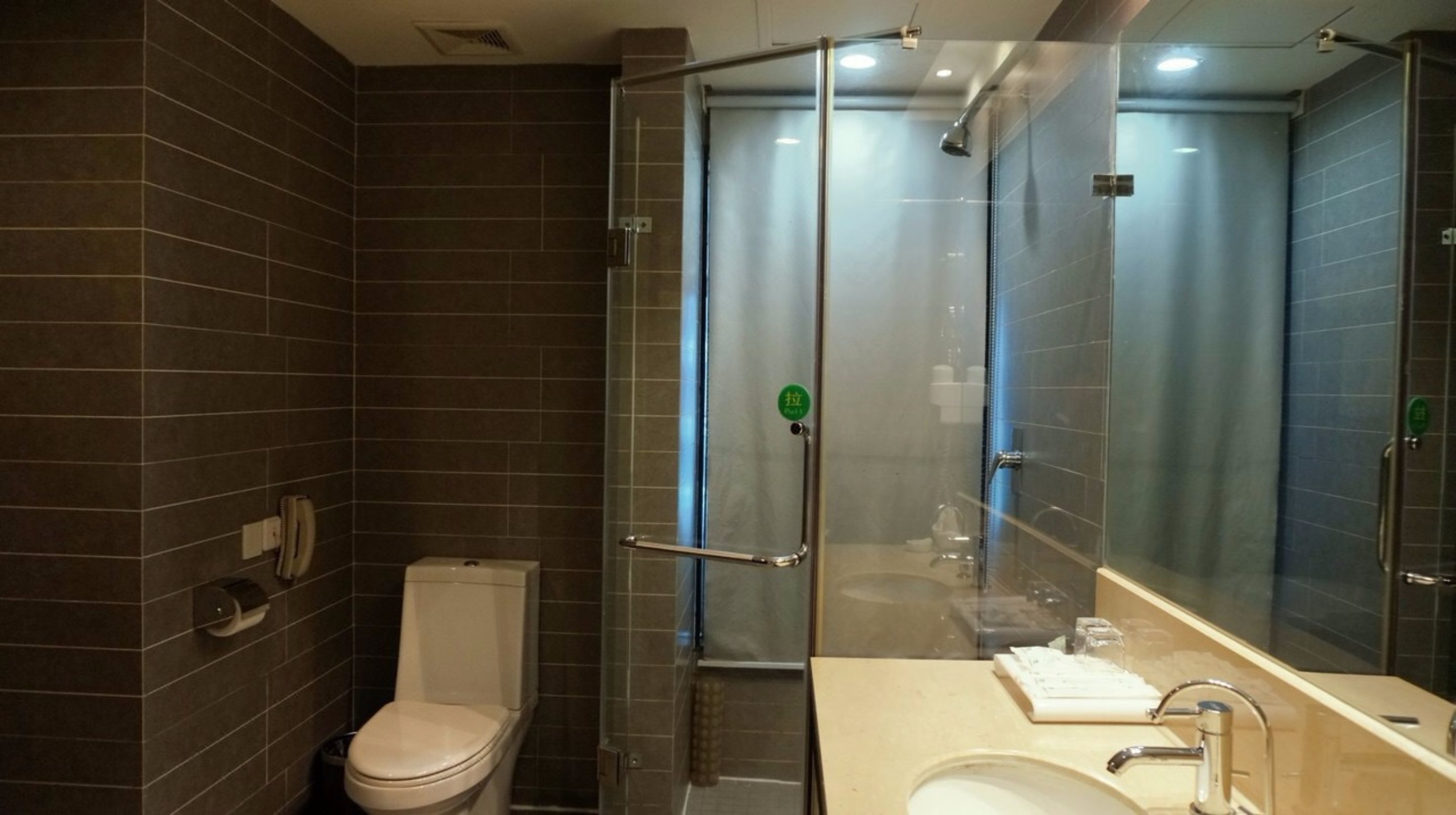 Une salle de bain moderne avec une douche à parois de verre, des toilettes et un lavabo avec un miroir.