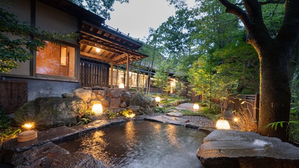 A traditional Japanese-style building with a koi pond, stone lanterns, and a wooden deck. - Nihon No Ashitaba (Yufu)