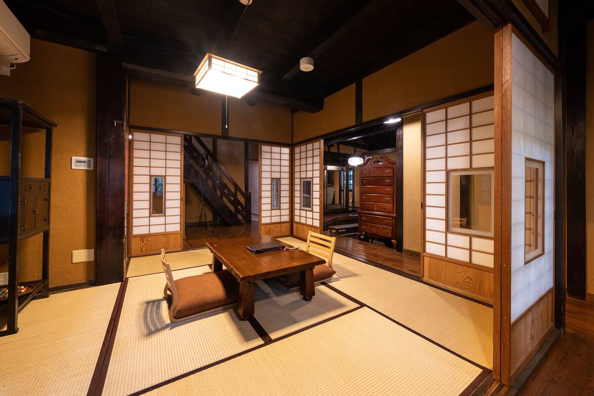 A traditional Japanese room with tatami flooring, a low wooden table, and sliding shoji doors.