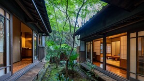 A traditional Japanese-style building with wooden floors, tatami mat rooms, and a garden with a wooden deck. - Nihon No Ashitaba (Yufu)