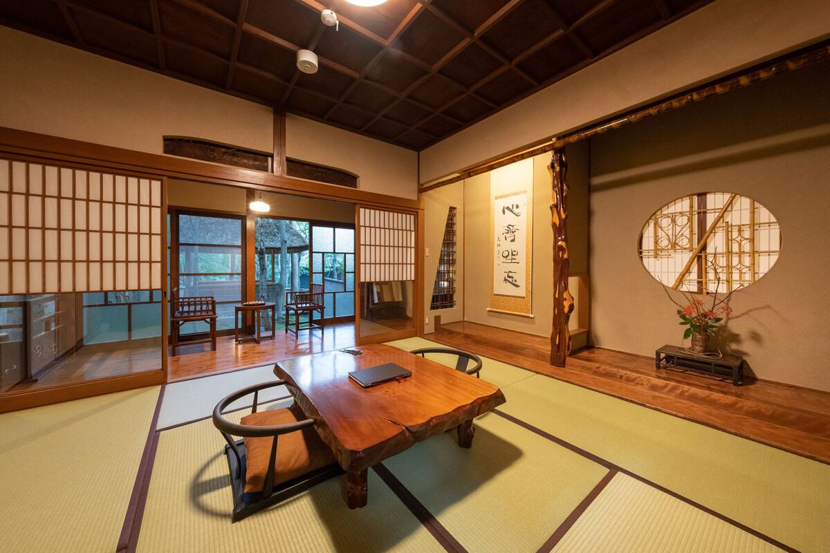 A traditional Japanese room with tatami flooring, a low wooden table, and sliding doors.