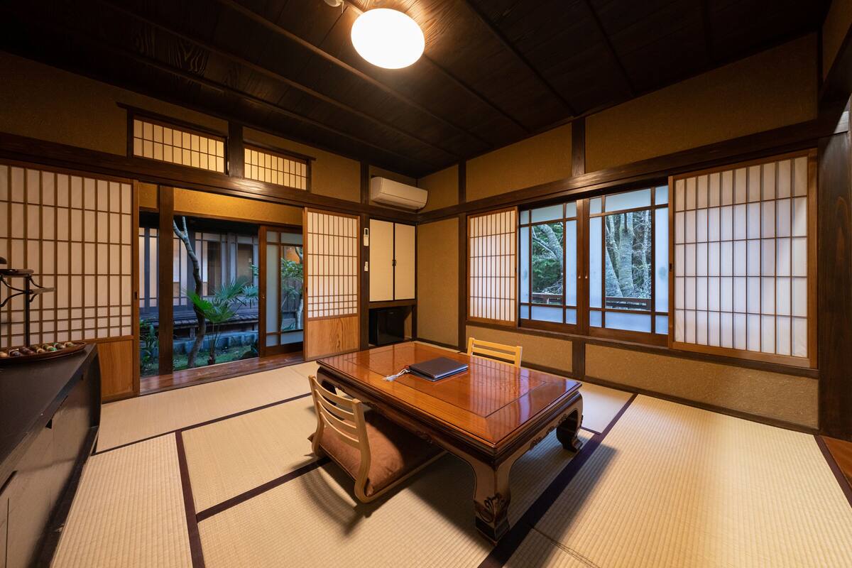 A traditional Japanese room with tatami flooring, a low wooden table, and sliding shoji doors.