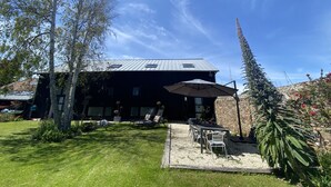A house with a patio area, outdoor seating, and a garden. - A boat house on the beach (Paimpol)
