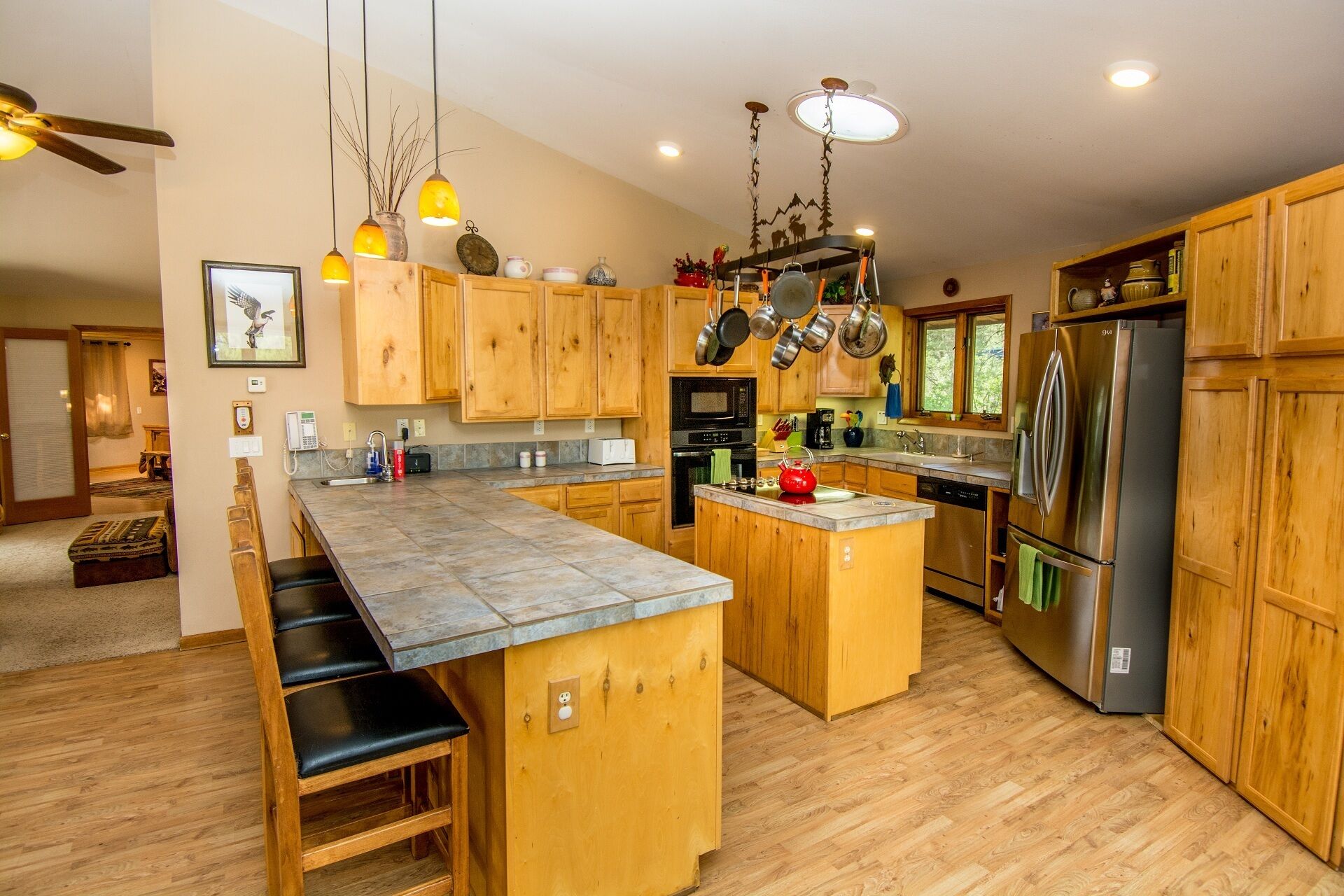 A spacious kitchen with wooden cabinets, a central island, and modern appliances.