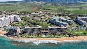 Una località balneare con diversi edifici a grattacielo, una spiaggia e montagne sullo sfondo.