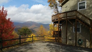 Une cabane en bois dotée d’un balcon donnant sur un paysage montagneux.