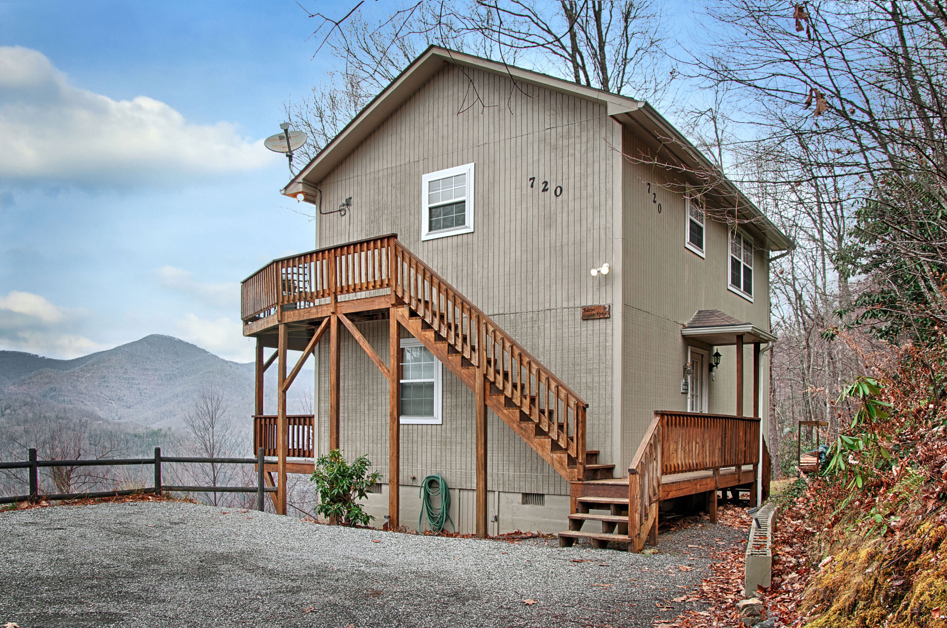 A two-story wooden house with a balcony and a staircase leading to the second floor.
