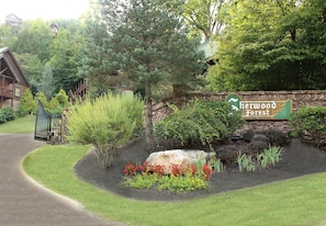 Un espace aménagé avec un mur en pierre, un grand rocher et un panneau indiquant l’hôtel Sherwood Forest.