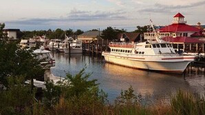 A marina with boats docked, a building with a red roof, and a waterfront view. - Bear Trap Dunes * 4BR Luxury Resort home (Ocean View)
