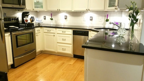 A modern kitchen with white cabinetry, stainless steel appliances, and a wooden floor. - Great South End / Back Bay location, 1 bed condo near T station  (Boston)