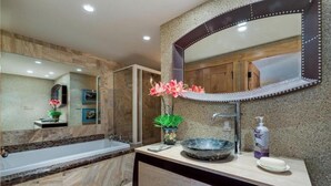 Un baño moderno con un espejo grande, una bañera, un lavabo y plantas decorativas.