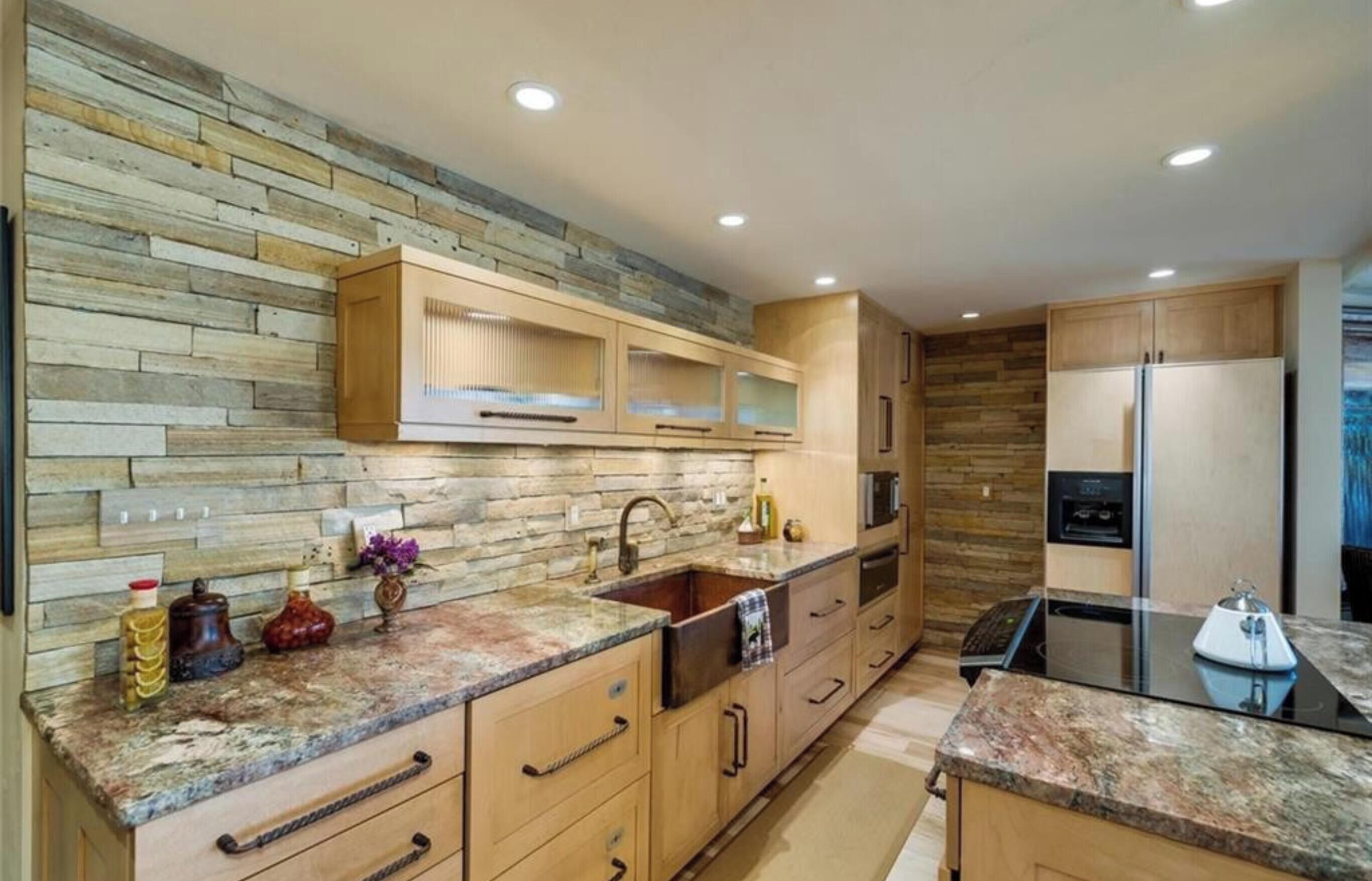 A modern kitchen with wooden cabinetry, a granite countertop, and built-in appliances.