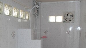 A bathroom with a toilet, a shower, and a sink. - Ban Sukjai Resort (Khao Kho)