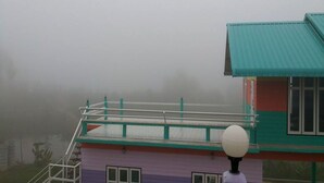 A multi-story building with a green roof and a purple lower section. - Ban Sukjai Resort (Khao Kho)