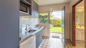 A modern kitchen with a built-in microwave, stainless steel sink, and a dishwasher.