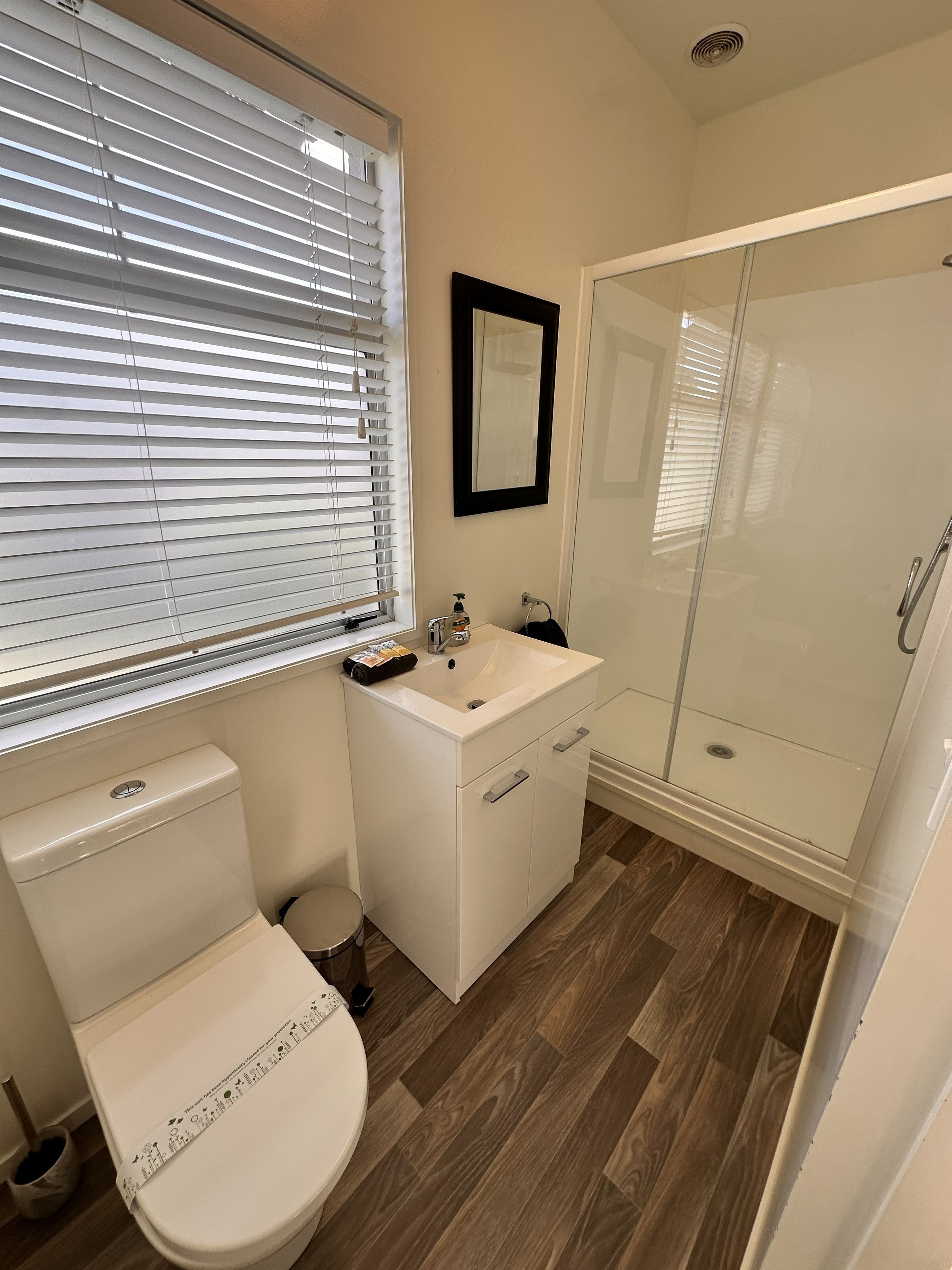 A bathroom with a toilet, sink, and shower.