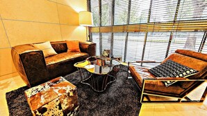 A modern living room with a sofa, armchair, and coffee table. - Hotel Cullinan (Seoul)