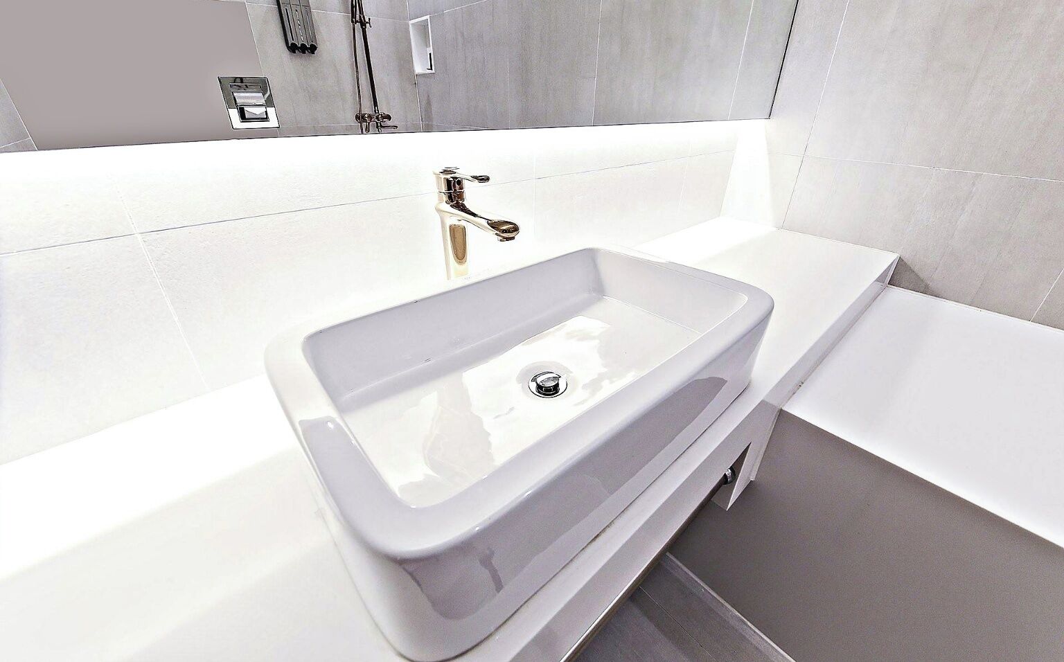 Une salle de bain moderne avec une baignoire blanche, un lavabo rectangulaire et un espace douche.