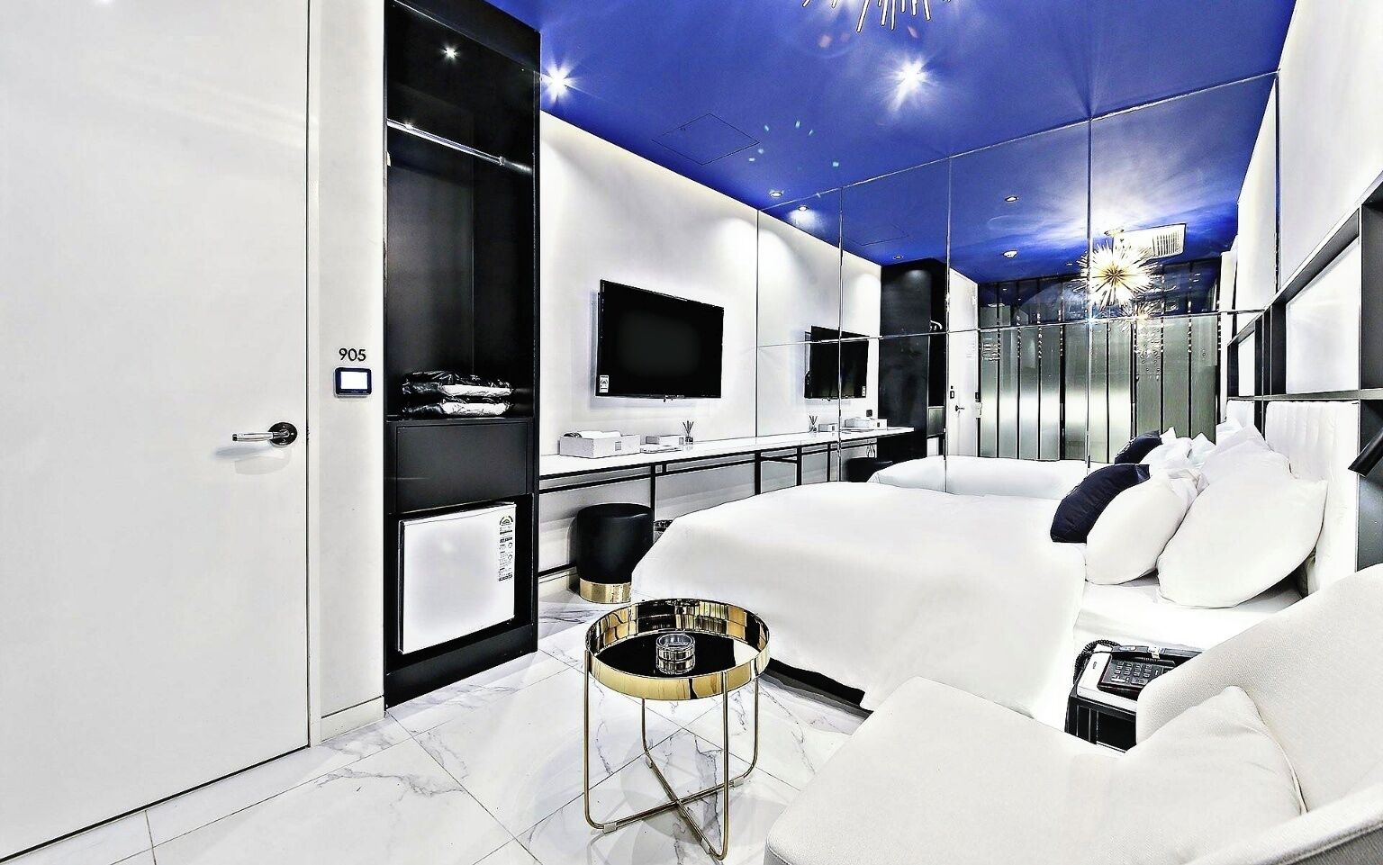 Habitación de hotel moderna con una cama grande, un escritorio, un televisor y un baño.